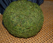 A large green ball of compacted tea leaves.