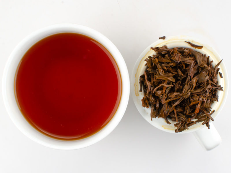 Cupped infusion of Dianhong Gongfu black tea and strained leaves.