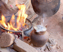 Pouring boiling water in to pottery after roasting the tea inside the pottery.