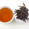 Cupped infusion of Laocong Shuixian rock wulong tea and strained leaves.