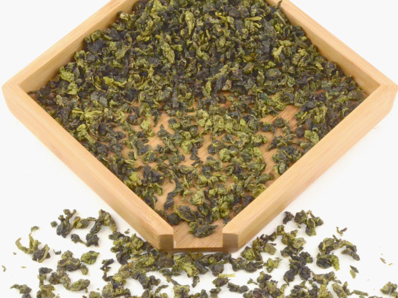 Maliu Mie (Monkey Picked) Anxi wulong tea dry leaves in a wooden display box.