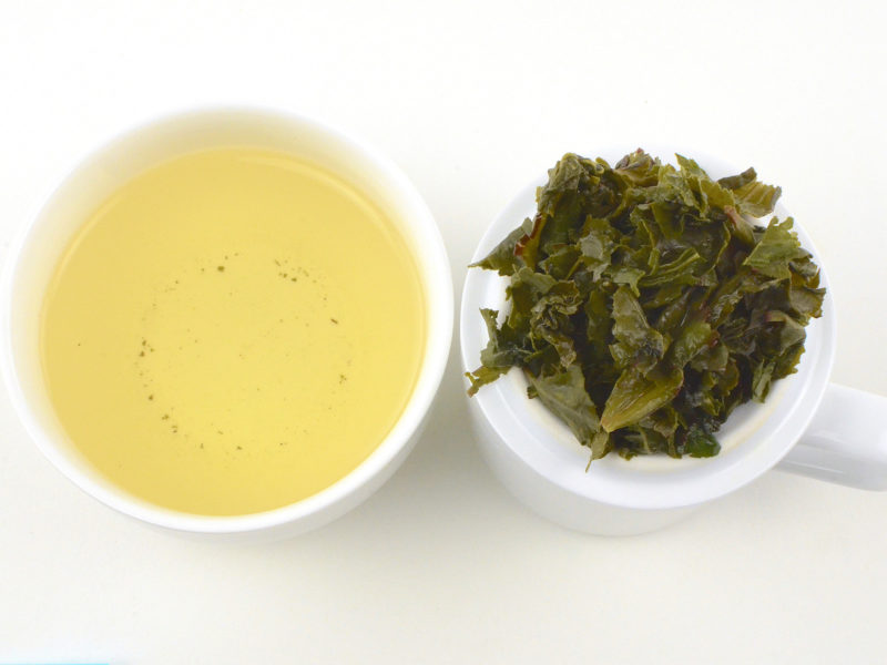 Cupped infusion of Maliu Mie (Monkey Picked) Anxi wulong tea and strained leaves.