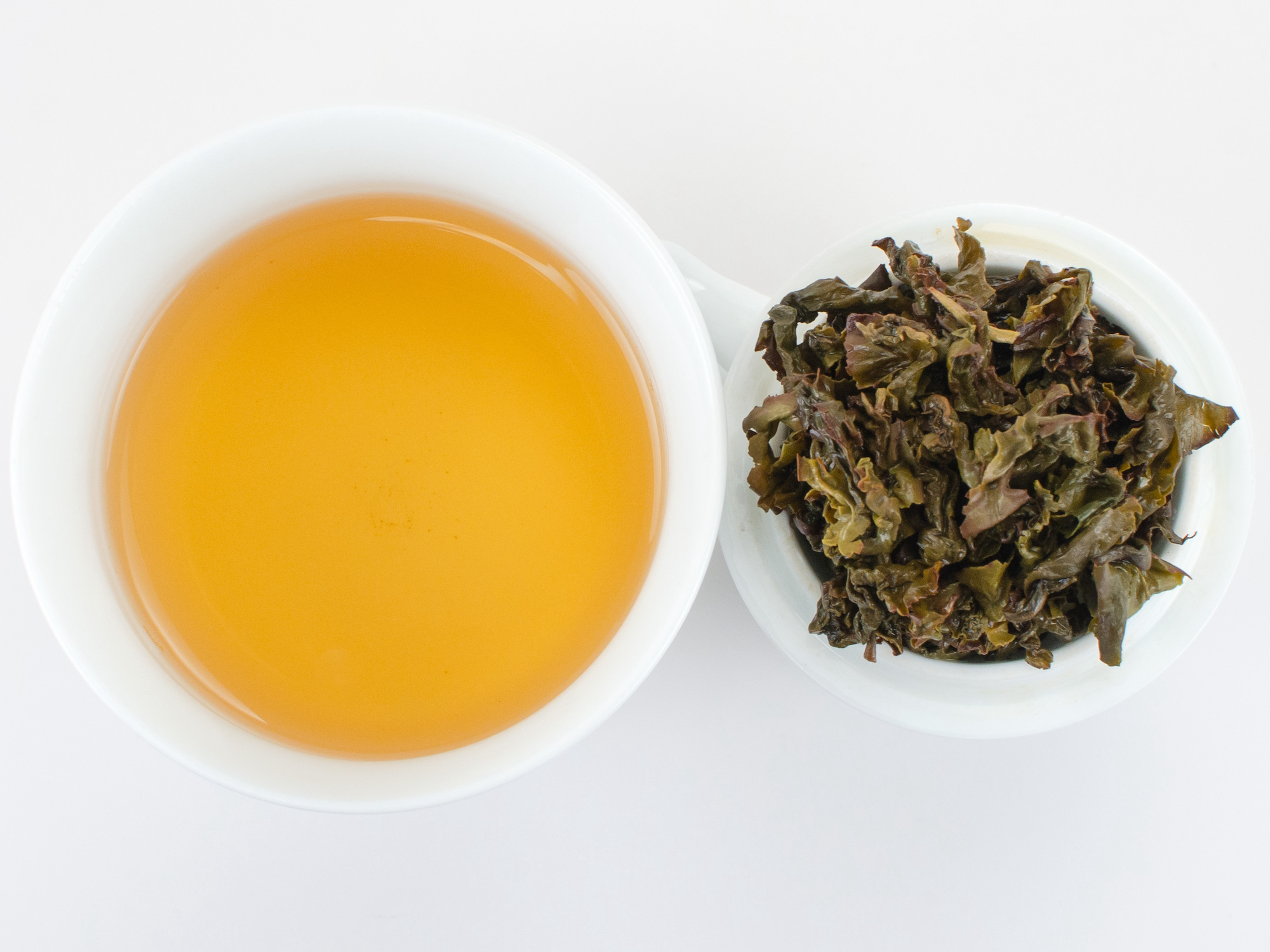 Cupped infusion of Ma Liu Mi (Monkey Picked) Anxi wulong tea and strained leaves.