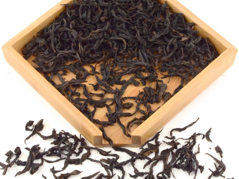 Qi Dan rock wulong tea dry leaves in a wooden display box.