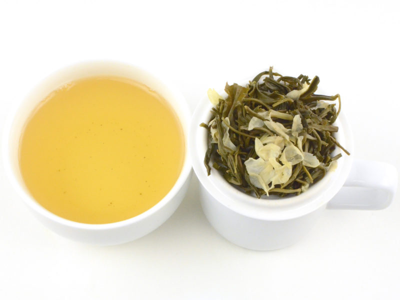 Cupped infusion of White Cloud Jasmine scented green tea and strained leaves.
