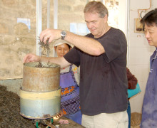 Tea master Hu Hao Ming directs Austin to put puer mao cha in a mold to steam.