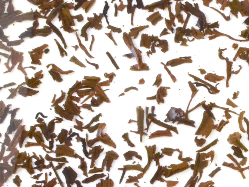 Lapsang Souchong wet tea leaves floating in clear water.