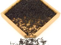 Tongmu Lapsang Souchong black tea dry leaves in a wooden display box.