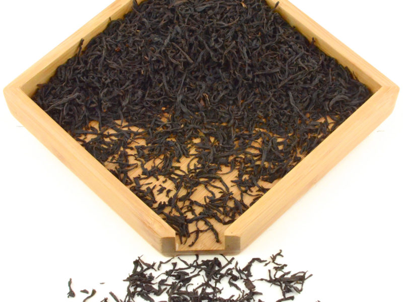 Tongmu Lapsang Souchong black tea dry leaves in a wooden display box.