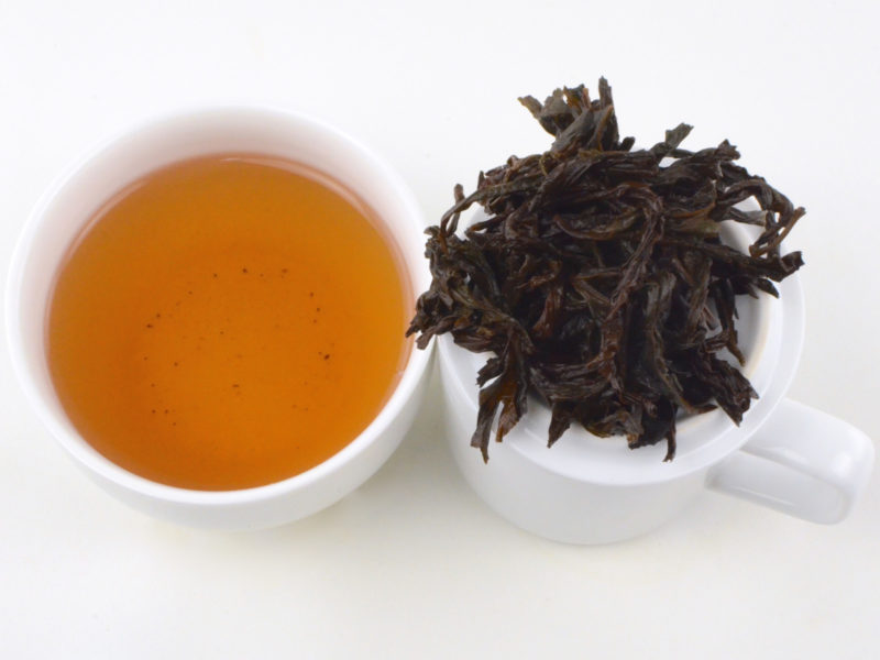 Cupped infusion of Shuixian rock wulong tea and strained leaves.