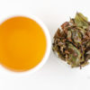 Cupped infusion of Shou Mei (Longevity Eyebrow) white tea and strained leaves.