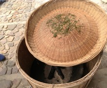 Traditional way to roast green tea on a domed round bamboo tray over charcoal.