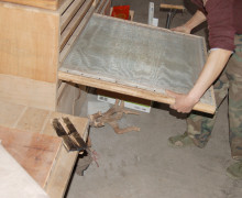 The frame with the leaves held between mesh being inserted into the oven.