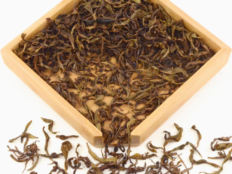 Bai Ji Guan (White Rooster Crest) rock wulong tea dry leaves in a wooden display box.