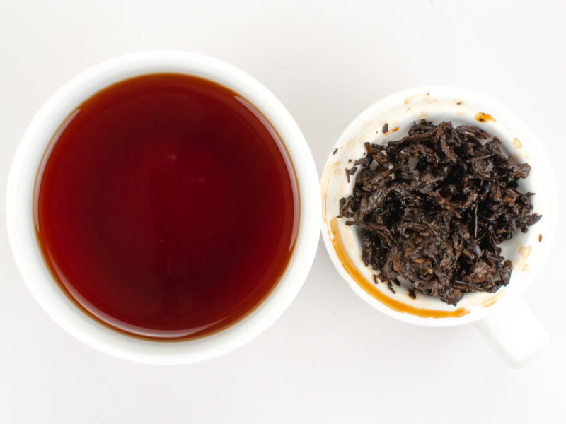 Cupped infusion of Ma Guo Tou tea and strained leaves