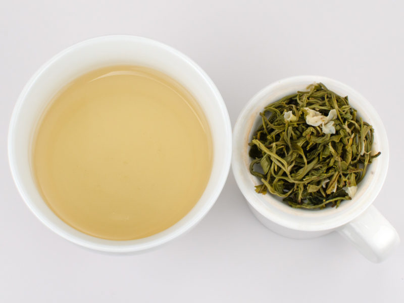 Cupped infusion of Bi Tan Piao Xue (Snow Drop Jasmine) scented green tea and strained leaves.