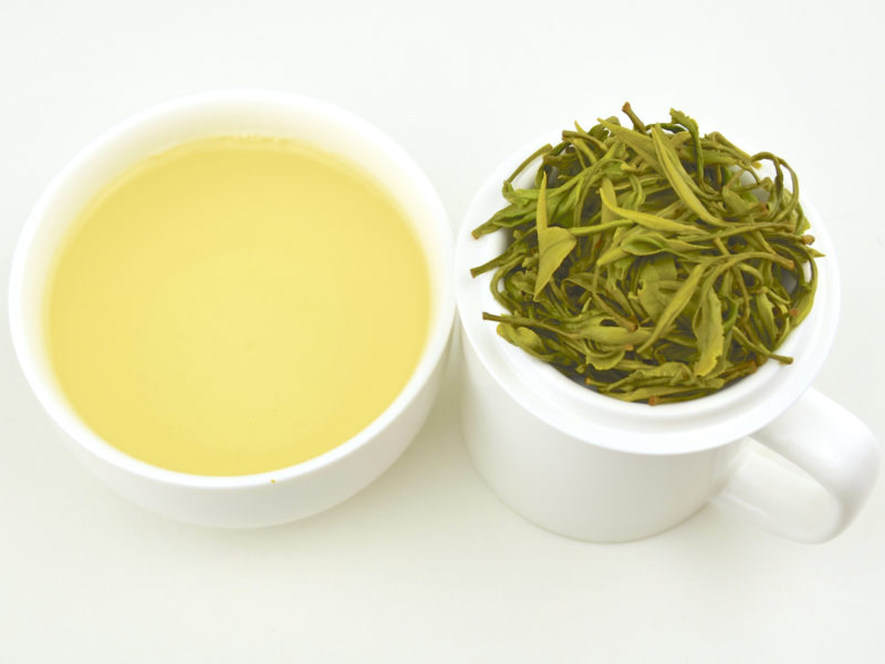 Cupped infusion of Huangshan Maofeng green tea and strained leaves.