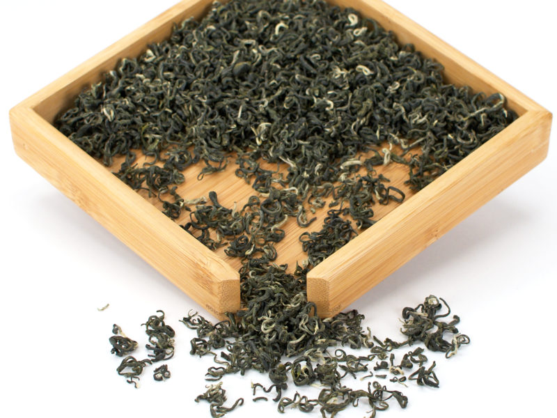 Mengding Maofeng green tea dry leaves in a wooden display box.