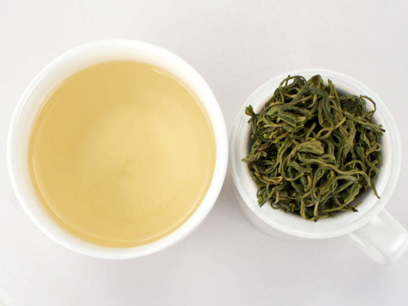 Cupped infusion of Mengding Maofeng green tea and strained leaves.
