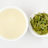 Cupped infusion of Guzhu Zisun (Purple Bamboo Shoot) tea and strained leaves.
