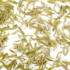 Mengding Ganlu (Sweet Dew) green tea leaves floating in clear water.