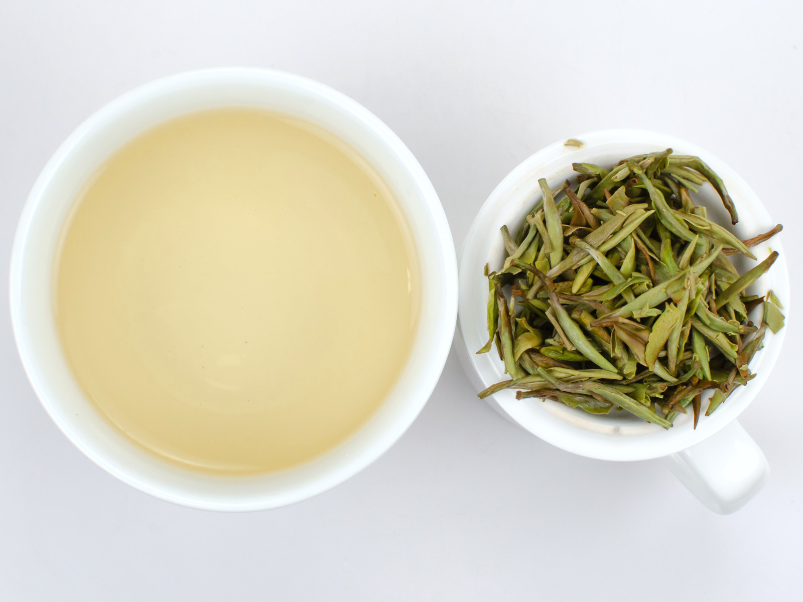 Cupped infusion of Baihao Yinzhen tea and strained leaves.