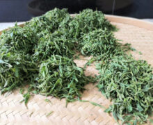 a couple piles of tea leaves after being fried in a wok. Each pile has around 300 grams of tea leaves, which is 1 portion that is fried at a time.