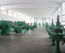 Teal machines in a white room. These are used for kneading and drying Misty New Top organic green tea.