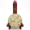 Unwrapped Bai Long Xu (White Dragon Whiskers) white puer cake displayed on a stand to show the leaves.