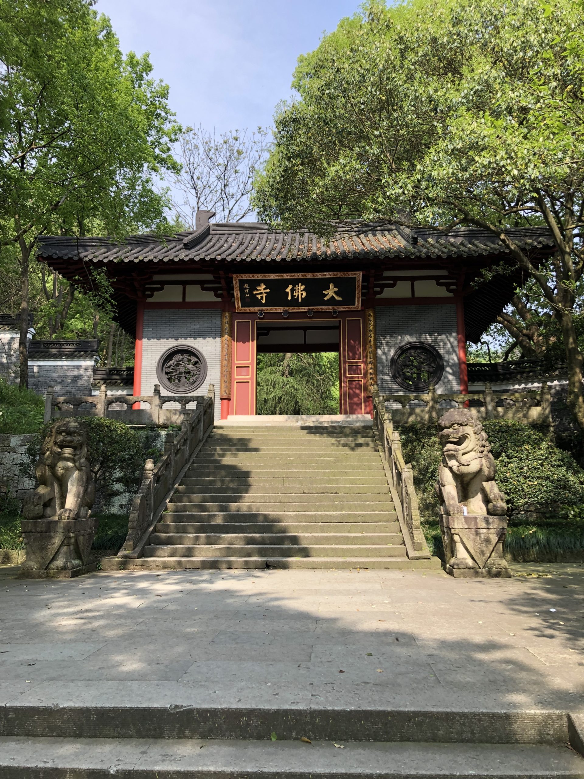 The entrance to Da Fo Temple in Zhejiang, with an angled roof over an outdoor archway.