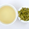 Cupped infusion of Shifeng Longjing and strained tea leaves.