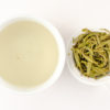 Cupped infusion of Junshan Yinzhen yellow tea and strained leaves.
