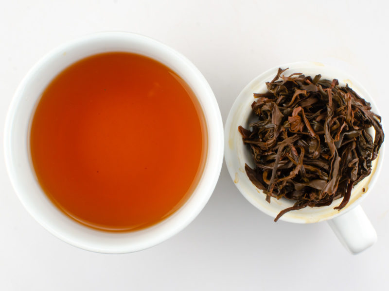 Cupped infusion of Laoshu Dianhong (Old Tree Yunnan) tea and strained leaves.