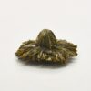 The compact dry shape of a piece of Chrysanthemum Green blooming display tea.