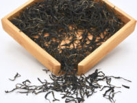 Zijuan Chuncha sheng puer tea dry leaves in a wooden display box.