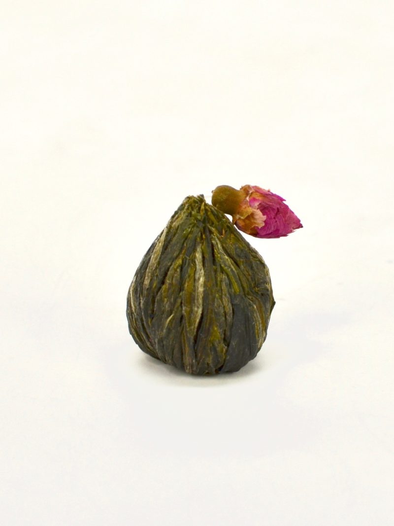 A closed, dry ball of rose jasmine blooming display tea.