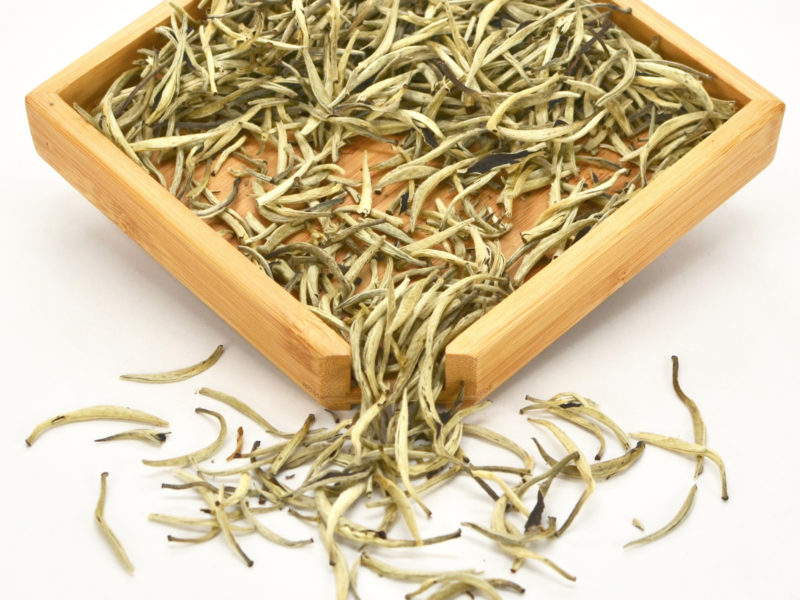 White Dragon Whiskers dry tea leaves in a wooden display box.