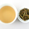 Cupped infusion of Bai Long Xu (White Dragon Whiskers) Yunnan white tea and strained leaves.