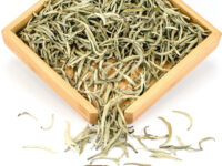 Bai Long Xu (White Dragon Whiskers) Yunnan white tea dry tea leaves in a wooden display box.
