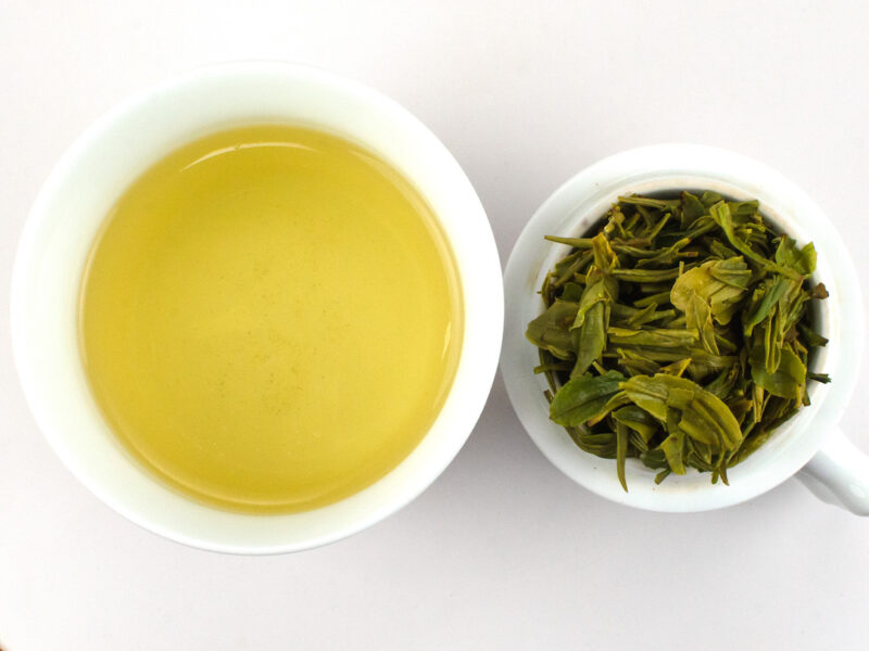 Cupped infusion of First Pluck Shifeng Lonjing green tea and strained leaves.