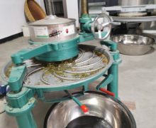 A kneading machine twisting the moist fried tea leaves.