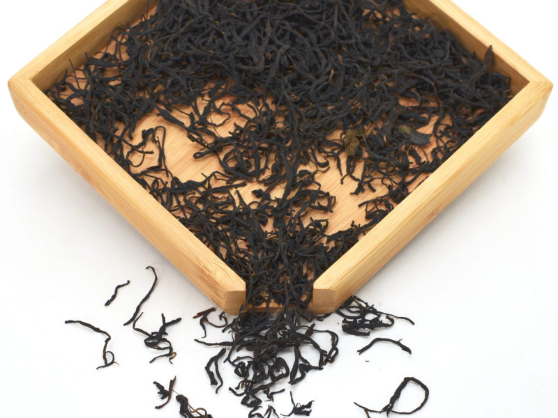 Anji Hong black tea dry leaves in a wooden display box.