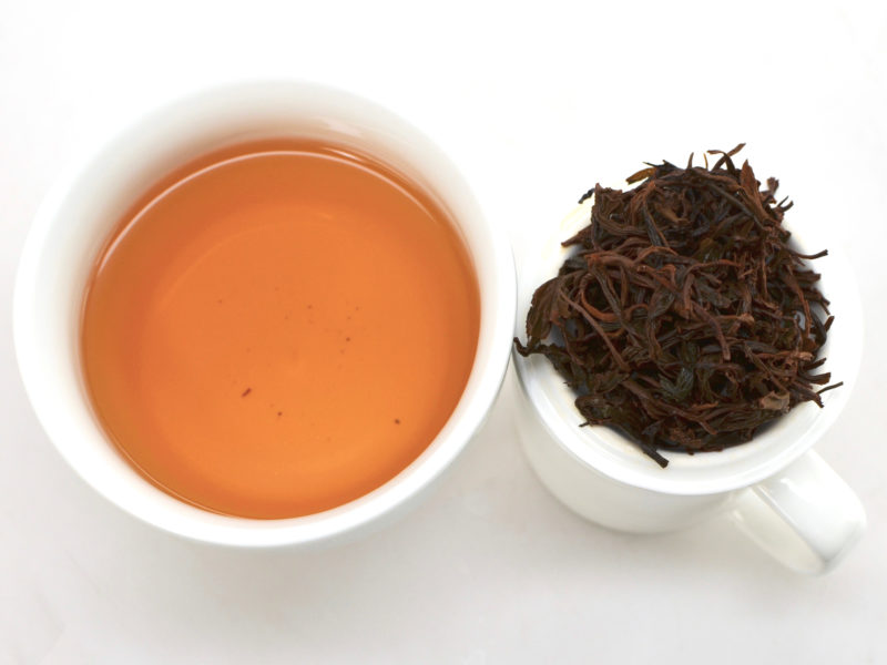 Cupped infusion of Anji Hong black tea and strained leaves.