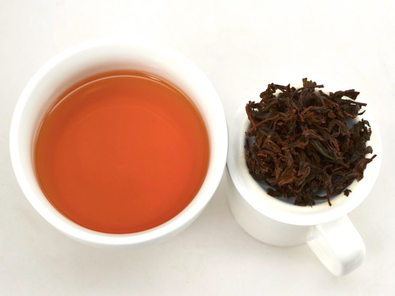 Cupped infusion of Zui Chun Fang (Drunken Peach) black tea and strained leaves.