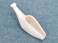 Angle view of white porcelain tea spoon.