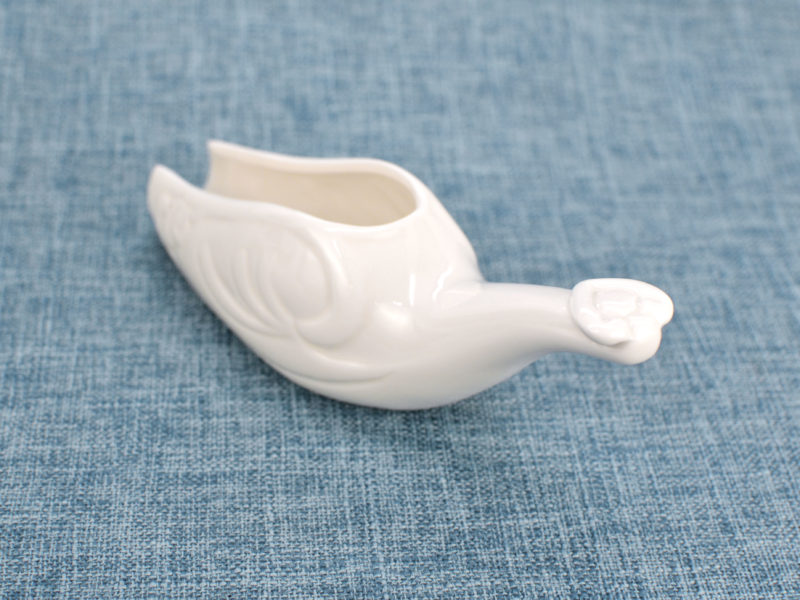 Handle detail on white porcelain tea spoon.
