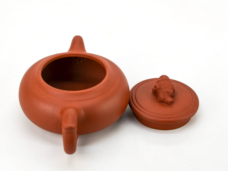 Lucky toad yixing clay pot with lid open to show built in strainer behind spout.