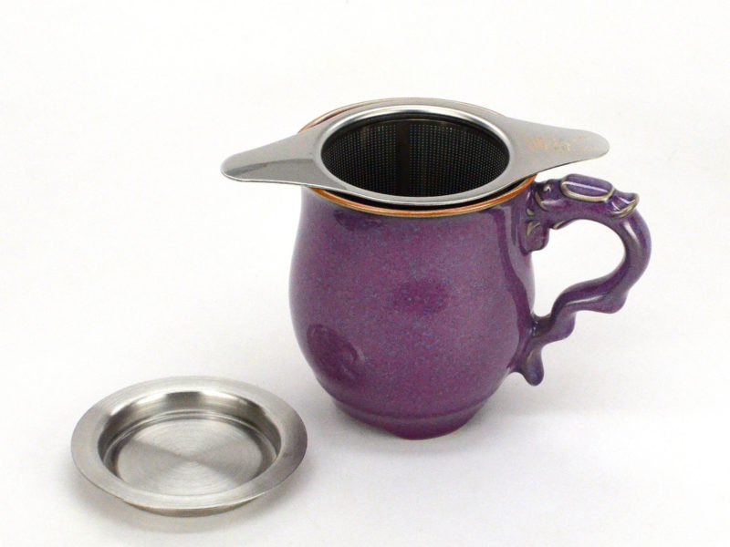 Stainless steel strainer being used as an infuser in a large cup.