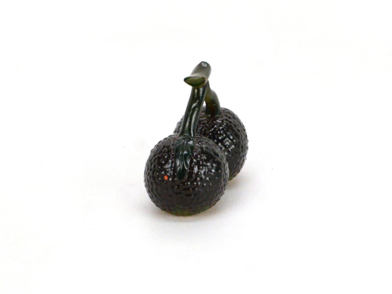 Angle view of color changing litchi fruit tea pet, dark green when cold.