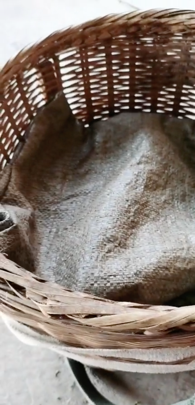 A large round woven basket covered with a tarp.
